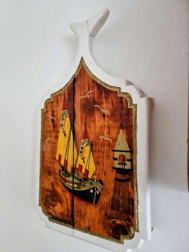 a wooden picture of a sailboat on a wall at Casa Mafalda in Chioggia
