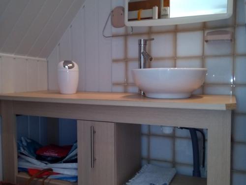 une salle de bain avec un lavabo et une vasque sur un comptoir dans l'établissement Maison agréable proche plage et bourg, 6 couchages, terrasse et équipements complets, La Guérinière - FR-1-224B-42, à La Guérinière