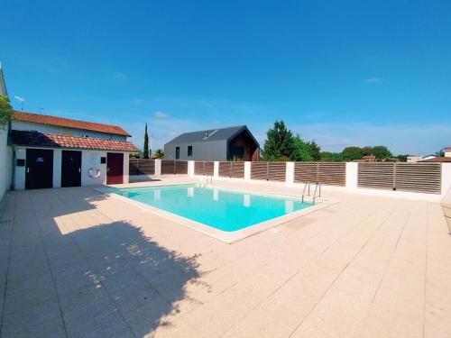 - une piscine au milieu d'un patio dans l'établissement La Baignade de Montaigu, piscine et garage couvert, à Bayonne