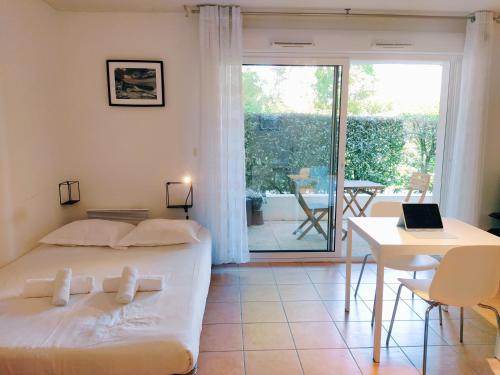 une chambre avec un lit et une table avec un ordinateur portable dans l'établissement La Baignade de Montaigu, piscine et garage couvert, à Bayonne