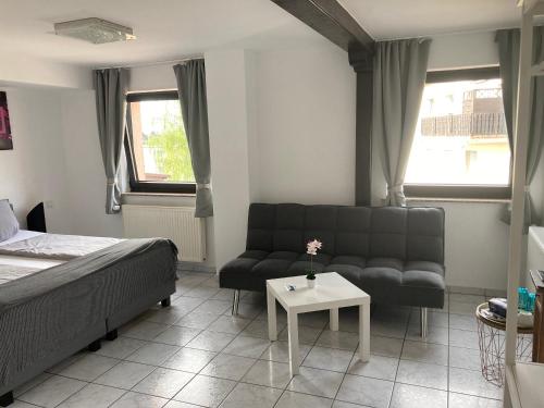um quarto com uma cama, um sofá e uma mesa em Mikroapartments Klarenthal em Saarbrücken