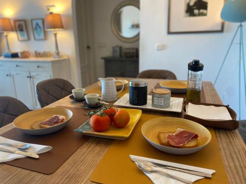 een houten tafel met borden met eten erop bij Pepe Beach Vista al Mar Apartment Estepona in Estepona