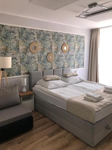 Un dormitorio con una cama grande y una silla. en Villa Magda, en Ustronie Morskie