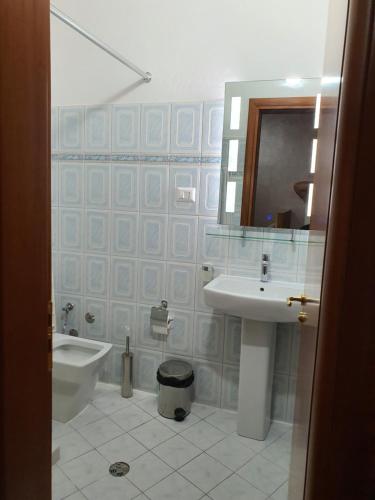 a bathroom with a sink and a toilet and a mirror at Kompleksi GJONI in Fier