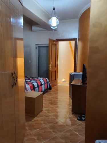 a room with a bedroom with a bed and a desk at Kompleksi GJONI in Fier