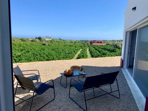 a patio with two chairs and a table on a balcony at Hortas de Baixo in Luz de Tavira