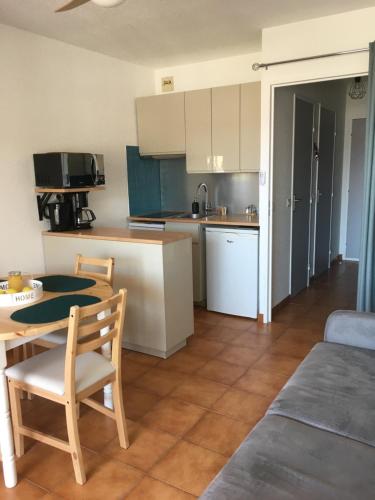 une cuisine et une salle à manger avec une table et des chaises dans l'établissement L’azur, au Lavandou