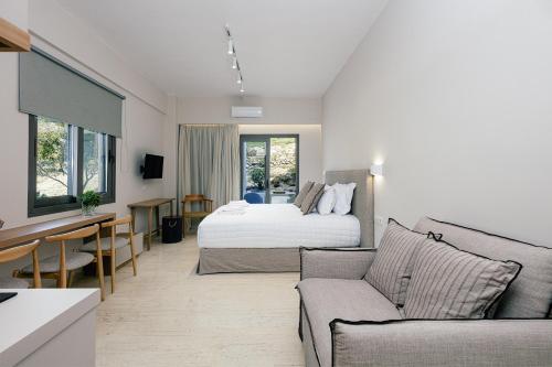 a bedroom with a bed and a living room at Ariadne Suites in Plakias