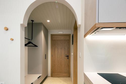 an arched hallway with a wooden door in a house at Ariadne Suites in Plakias