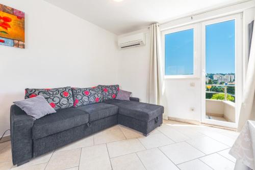 a living room with a couch and a large window at Apartments Maria in Dubrovnik