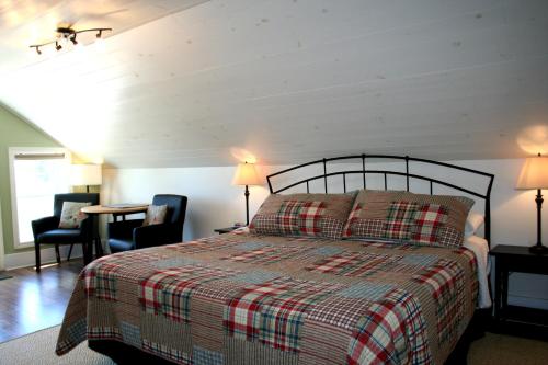 a bedroom with a bed and two chairs and a table at Hadovka Lakeside Inn in Wellington