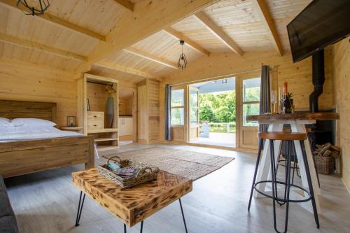 a log cabin bedroom with a bed and a table at Nestledstays- Primrose in Arundel