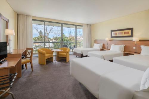 ポンタ・デルガダにあるSao Miguel Park Hotelのベッド2台とデスクが備わるホテルルームです。