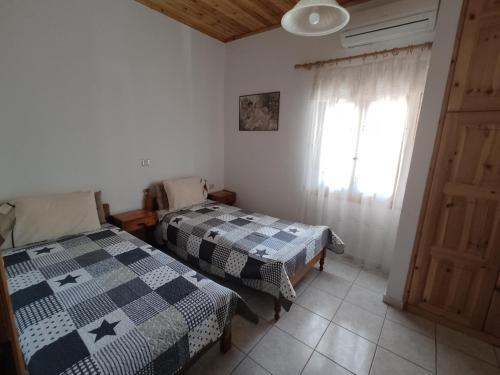 2 camas en una habitación con ventana en Nemesia resort en Anaxos