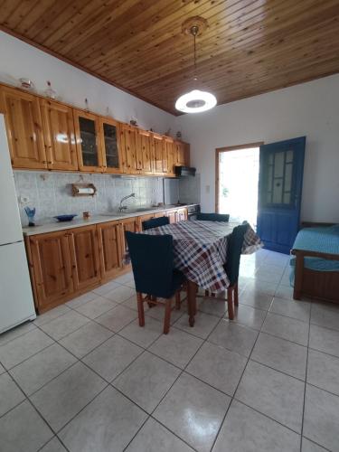 una cocina con mesa y sillas y una cocina con armarios de madera. en Nemesia resort, en Anaxos