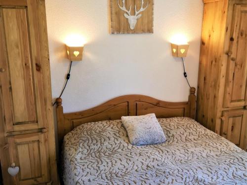 ein Schlafzimmer mit einem Bett mit zwei Lichtern an der Wand in der Unterkunft Chalet La Joue du Loup, 3 pièces, 7 personnes - FR-1-504-70 in Le Dévoluy