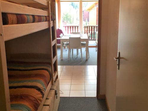 Zimmer mit Etagenbetten und einem Esszimmer mit einem Tisch in der Unterkunft Appartement La Joue du Loup, 2 pièces, 7 personnes - FR-1-504-76 in Le Dévoluy