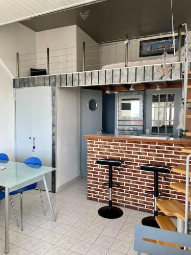 une cuisine avec une table et deux tabourets de bar dans l'établissement Le Front de mer - studio lumineux esplanade Mers, à Mers-les-Bains