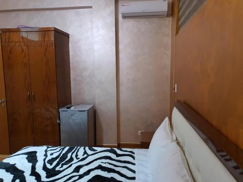 a bedroom with a zebra print bed and a closet at Kompleksi GJONI in Fier