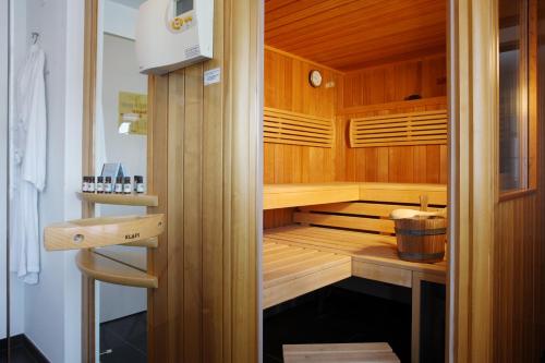 a sauna with wooden cabinets and a bucket in it at Hotel Ochsen in Menzingen