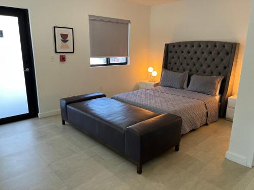 a bedroom with a bed and a leather ottoman at Renzzi Wynwood Apartments in Miami