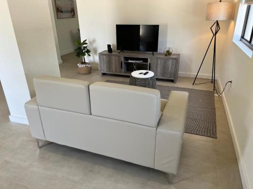 a white couch in a living room with a television at Renzzi Wynwood Apartments in Miami