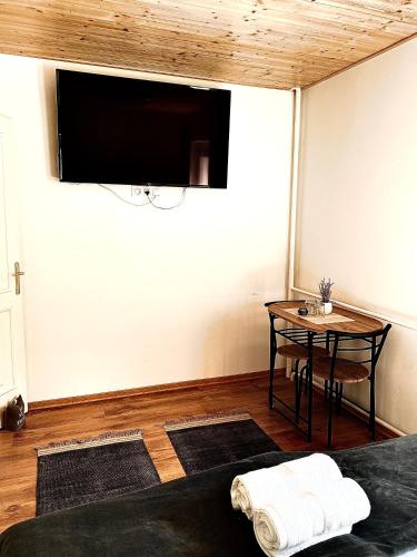 a room with a table and a tv on the wall at Fakanalas Fogadó in Pásztó