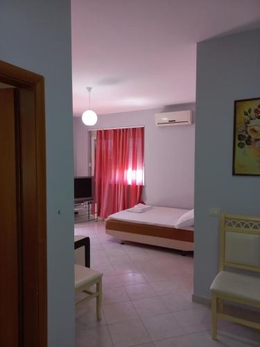 ヴロラにあるLungomare Apartament Sea view KORALのベッドルーム1室(ベッド1台、赤いカーテン付)