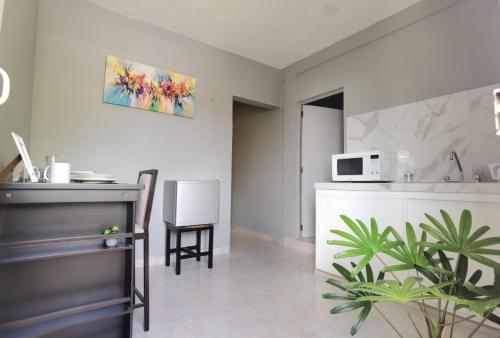 a kitchen with a sink and a counter with a table at 8th Street Suites in Cozumel