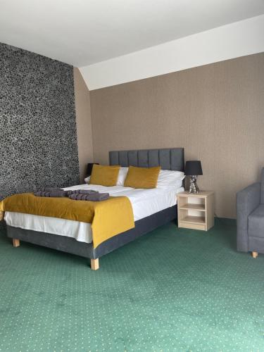 Apartament Zalesie في أوستروفو: غرفة نوم بسرير كبير وكرسي