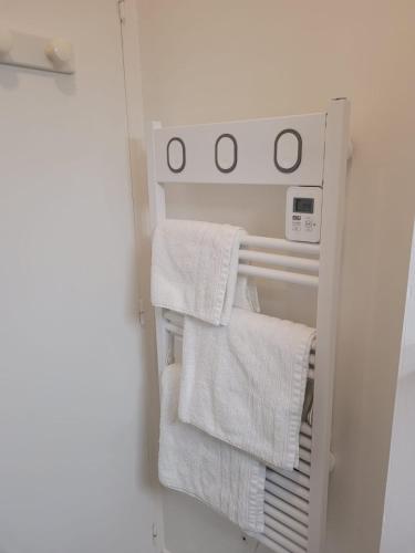 um toalheiro num frigorífico com toalhas brancas em Le Studio 64 em Rochefort