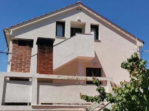 a white house with a brick at Apartment Porat 2 in Ugljan