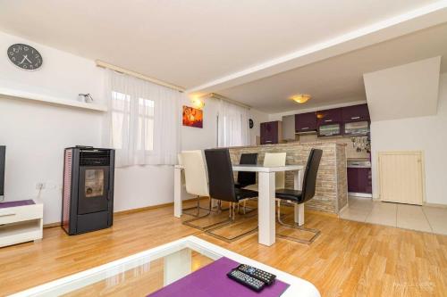a living room with a table and chairs and a kitchen at Apartment Alen in Veli Lošinj