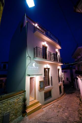 a white building with a sign on it at night at Eumorphia Studios & Apartments in Skiathos Town