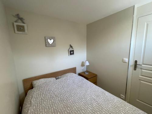 une chambre avec un lit et une horloge au mur dans l'établissement 2 pièces Les Coquillages - Hypercentre et Plage, à Houlgate