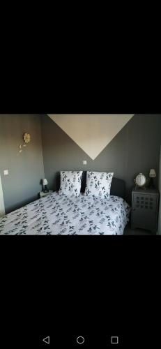 een slaapkamer met een bed met een bloemenbed bij Petite maison in Saint-Vigor-le-Grand
