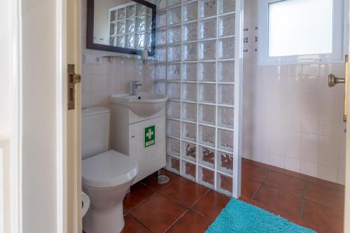 ein Badezimmer mit Toilette und Waschbecken in der Unterkunft Casa Beira Mar in Mosteiros