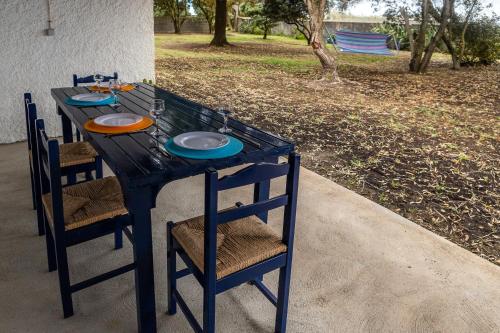 einem schwarzen Tisch mit Stühlen und Tellern darauf in der Unterkunft Casa Beira Mar in Mosteiros