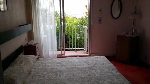 a bedroom with a bed in front of a window at La Voile D' Or in Cap d'Agde
