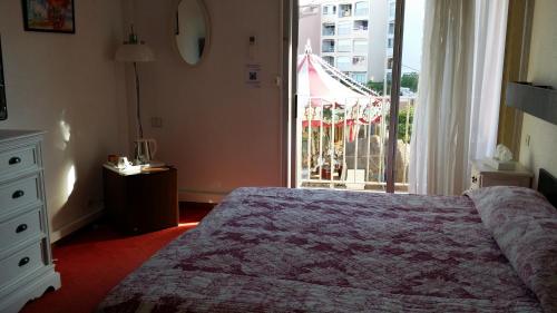a bedroom with a bed and a large window at La Voile D' Or in Cap d'Agde