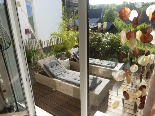 a balcony with a chair and a couch on a patio at Das Nest Winterberg in Winterberg