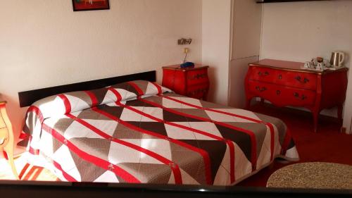 a bedroom with a bed and a red dresser at La Voile D' Or in Cap d'Agde