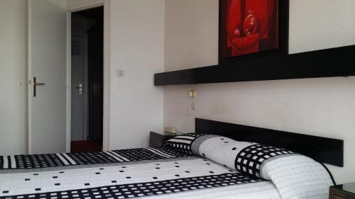 a bedroom with a bed with black and white pillows at La Voile D' Or in Cap d'Agde