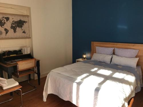 a bedroom with a large bed and a desk with a desk at Un paradis de verdure en plein centre ville in Périgueux