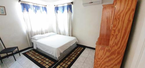 a small bedroom with a bed and a window at Malfranza Apartments in Bridgetown