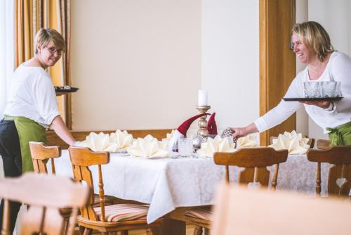 a man and woman standing around a table with a cake at Gasthof Martinhof in Sankt Martin im Sulmtal