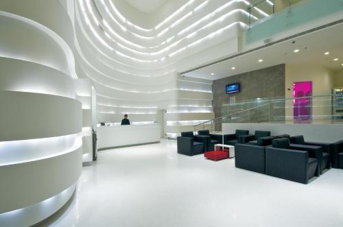 a lobby with chairs and a person in the background at Keys Select by Lemon Tree Hotels, Thiruvananthapuram in Trivandrum