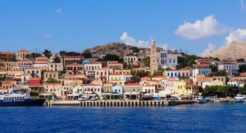 a group of houses on a hill next to the water at House Galini in Halki