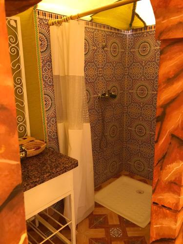 a bathroom with a shower with a shower curtain at Karim Sahara Prestige in Zagora