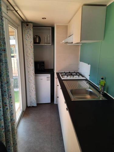 a small kitchen with a sink and a window at CHALETS MERCURE am Wallersee zum Vermieten in Helming